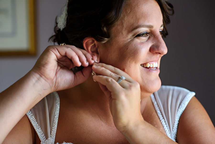 A bride putting on earrings before the first look.